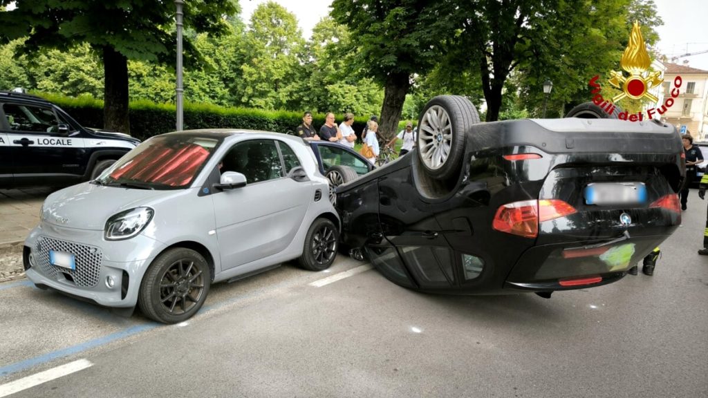 Si schianta contro due vetture parcheggiate, l'auto finisce capovolta