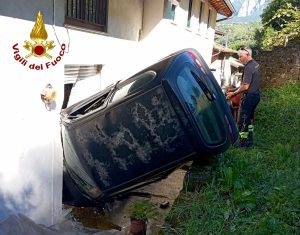 Auto parcheggiata si muove da sola: finisce in una scarpata e contro una casa